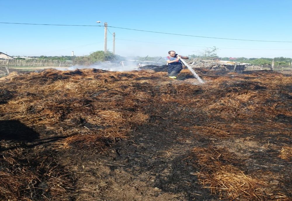  FOTO| Incendiu puternic la o șiră de baloți din paie. Camionetă făcută scrum